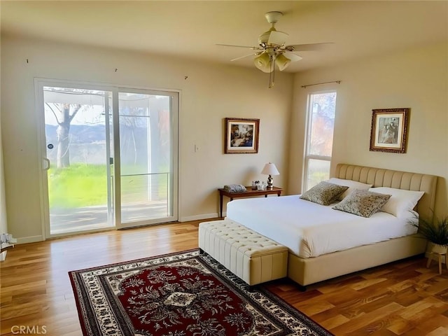 bedroom featuring light wood finished floors, baseboards, and access to exterior