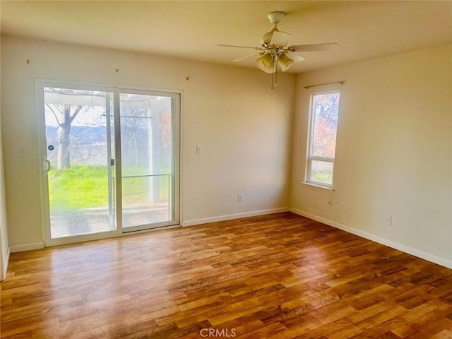 spare room with a ceiling fan, baseboards, and wood finished floors