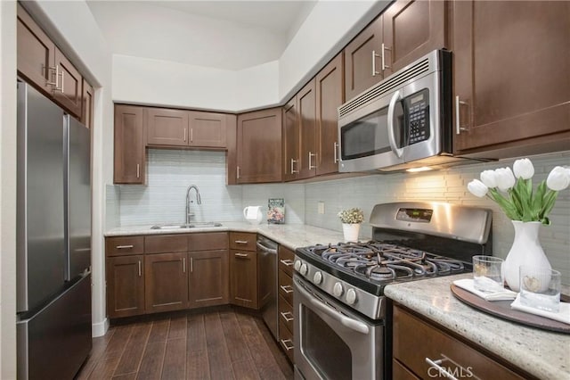 26511 Merienda Unit 7, Laguna Hills, CA 92656 - kitchen featuring appliances with stainless steel finishes, a sink, dark wood-style floors, light stone counters, and backsplash