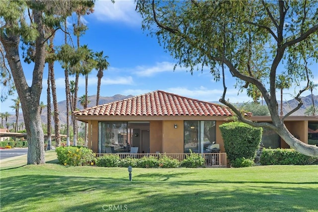 1 Valencia Dr, Rancho Mirage, CA 92270 - rear view of property with a tiled roof, stucco siding, a yard, and a mountain view