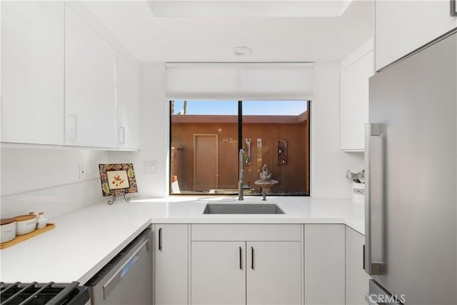 1 Valencia Dr, Rancho Mirage, CA 92270 - kitchen featuring appliances with stainless steel finishes, a sink, white cabinets, and light countertops