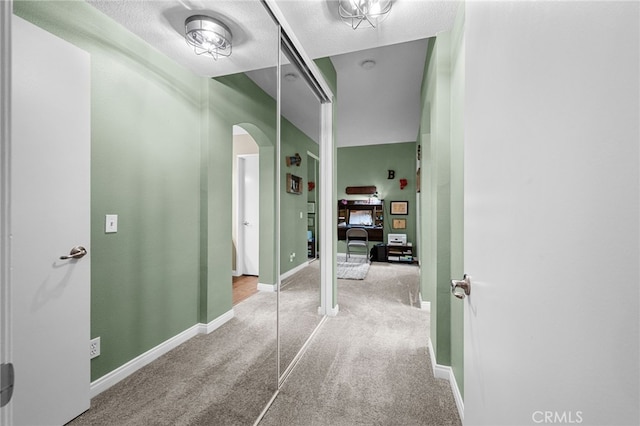 23412 Pacific Park Dr Unit 40H, Aliso Viejo, CA 92656 - corridor featuring arched walkways, carpet, a textured ceiling, and baseboards