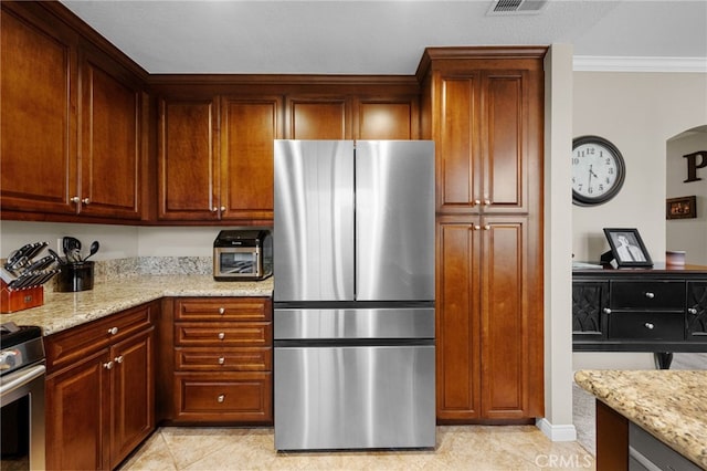 23412 Pacific Park Dr Unit 40H, Aliso Viejo, CA 92656 - kitchen with stainless steel appliances, light stone counters, crown molding, light tile patterned floors, and arched walkways