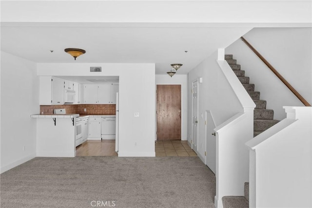 2220 Exposition Dr Unit 64, San Luis Obispo, CA 93401 - unfurnished living room featuring light colored carpet, stairway, and baseboards