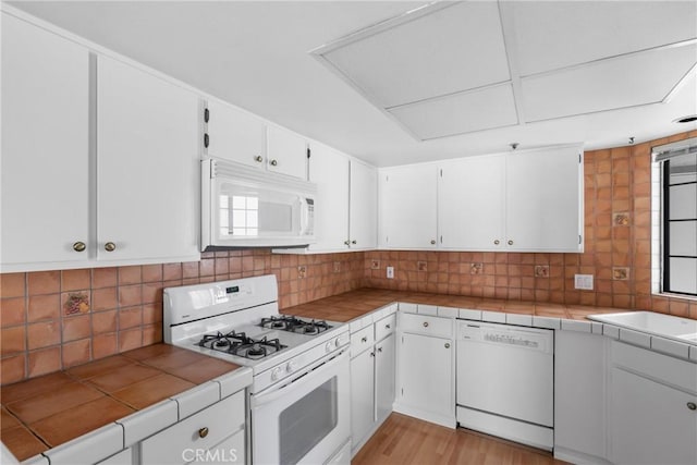 2220 Exposition Dr Unit 64, San Luis Obispo, CA 93401 - kitchen featuring white appliances, tile countertops, white cabinets, and tasteful backsplash