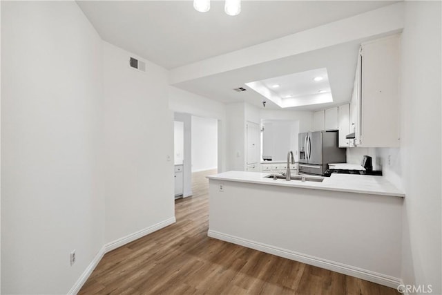 kitchen featuring a sink, baseboards, visible vents, gas range, and stainless steel fridge with ice dispenser