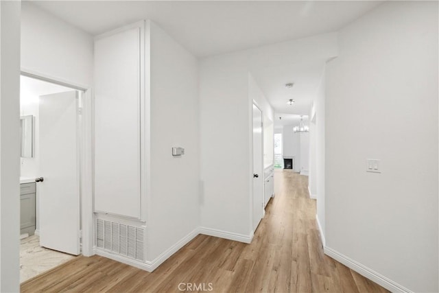 1450 Brett Pl Unit 205, San Pedro, CA 90732 - corridor featuring an inviting chandelier, baseboards, visible vents, and light wood-style floors