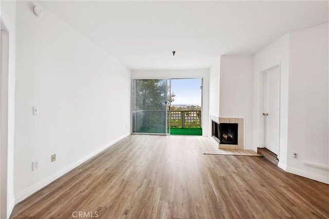 1450 Brett Pl Unit 205, San Pedro, CA 90732 - unfurnished living room featuring wood finished floors, a fireplace, and baseboards