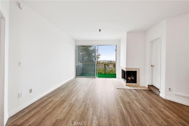 1450 Brett Pl Unit 205, San Pedro, CA 90732 - unfurnished living room featuring wood finished floors and a tiled fireplace