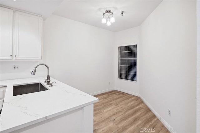 1450 Brett Pl Unit 205, San Pedro, CA 90732 - kitchen featuring white cabinetry, light wood-style floors, light stone counters, and a sink