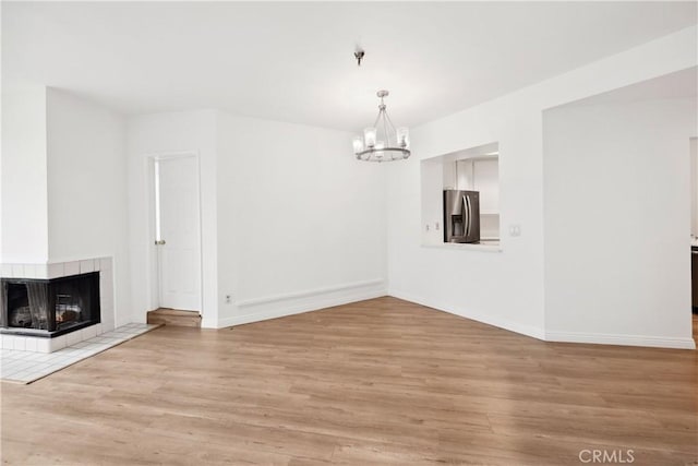 1450 Brett Pl Unit 205, San Pedro, CA 90732 - unfurnished living room featuring a chandelier, wood finished floors, and baseboards
