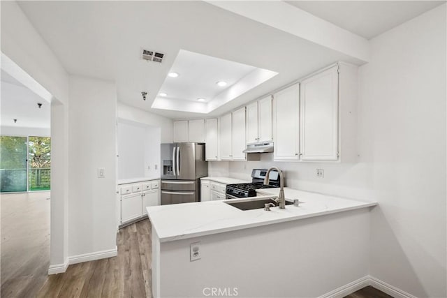 1450 Brett Pl Unit 205, San Pedro, CA 90732 - kitchen with stainless steel appliances, light wood-style flooring, under cabinet range hood, light stone countertops, and white cabinets