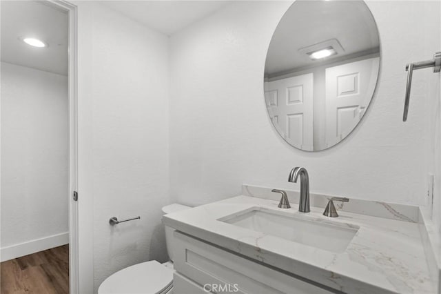 16 Encina, Irvine, CA 92620 - half bathroom with vanity, toilet, baseboards, and wood finished floors
