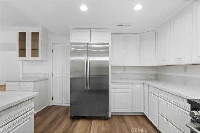 16 Encina, Irvine, CA 92620 - kitchen featuring stainless steel refrigerator, light stone countertops, dark wood-style flooring, visible vents, and white cabinetry
