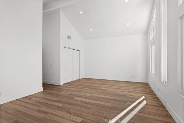 16 Encina, Irvine, CA 92620 - unfurnished bedroom with baseboards, high vaulted ceiling, visible vents, and wood finished floors