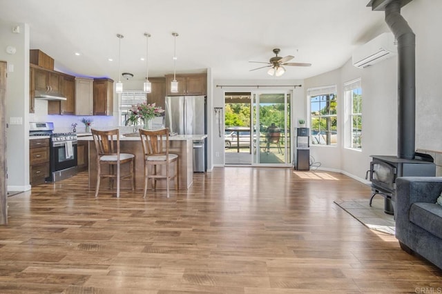 3465 Barrett Vw, Alpine, CA 91901 - kitchen featuring appliances with stainless steel finishes, open floor plan, a wood stove, an AC wall unit, and a ceiling fan