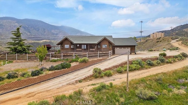 770 Roads End, Lebec, CA 93243 - rustic home featuring an attached garage, a mountain view, dirt driveway, and fence
