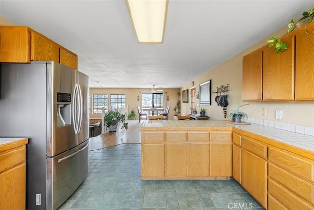 770 Roads End, Lebec, CA 93243 - kitchen featuring a peninsula, tile counters, open floor plan, and stainless steel refrigerator with ice dispenser