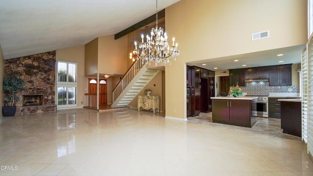 7816 Quartz Ave, Los Angeles, CA 91306 - unfurnished living room with high vaulted ceiling, stairs, a stone fireplace, and a chandelier
