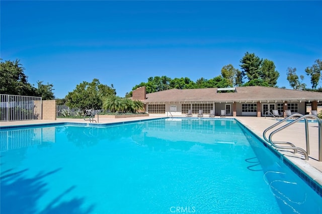 pool with fence and a patio