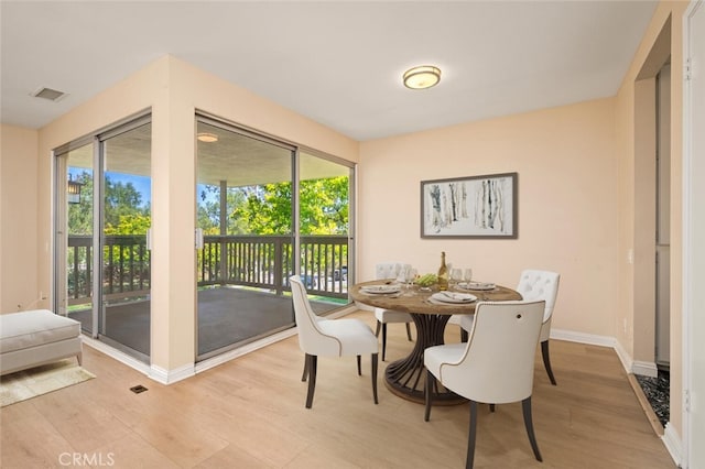 dining area with baseboards, a healthy amount of sunlight, visible vents, and light wood-type flooring