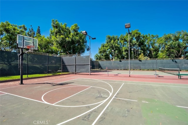 view of sport court featuring community basketball court, fence, and a tennis court