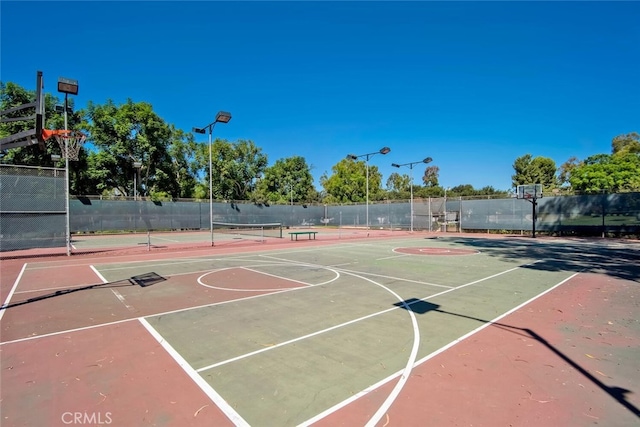 view of sport court with fence, a tennis court, and community basketball court