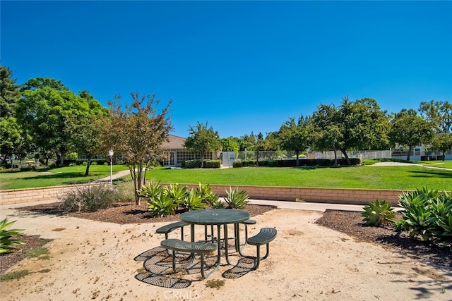 view of property's community with fence and a lawn