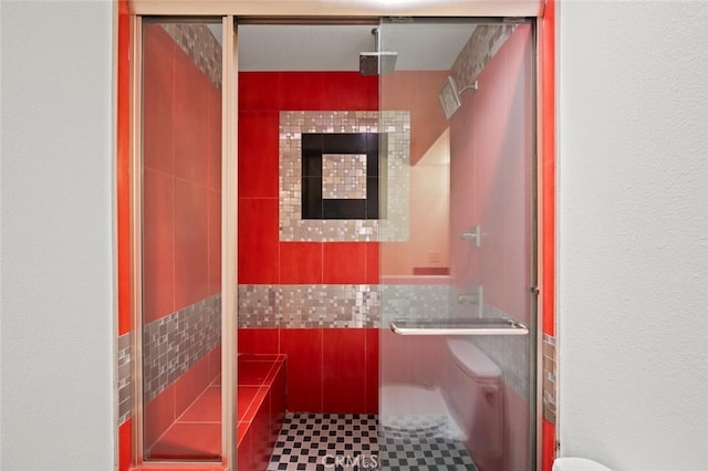 bathroom with toilet and a shower stall