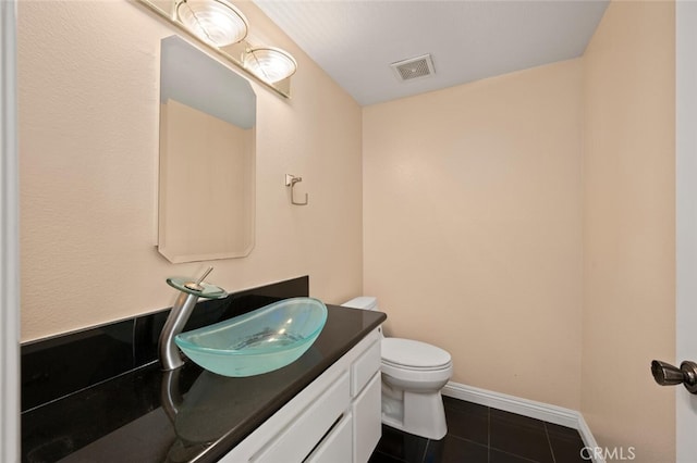 bathroom with toilet, tile patterned floors, vanity, and visible vents