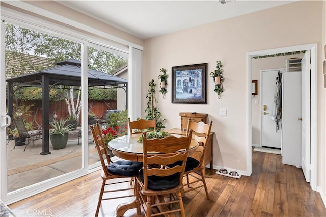 dining room with baseboards and hardwood / wood-style floors