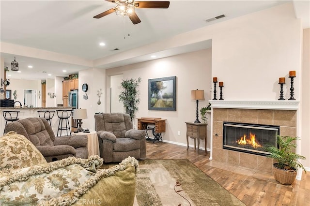 living area with a ceiling fan, recessed lighting, baseboards, visible vents, and wood finished floors