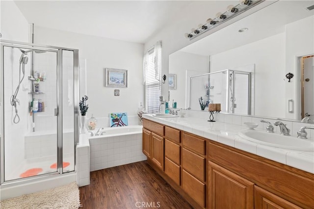 full bathroom with double vanity, a garden tub, a shower stall, and a sink