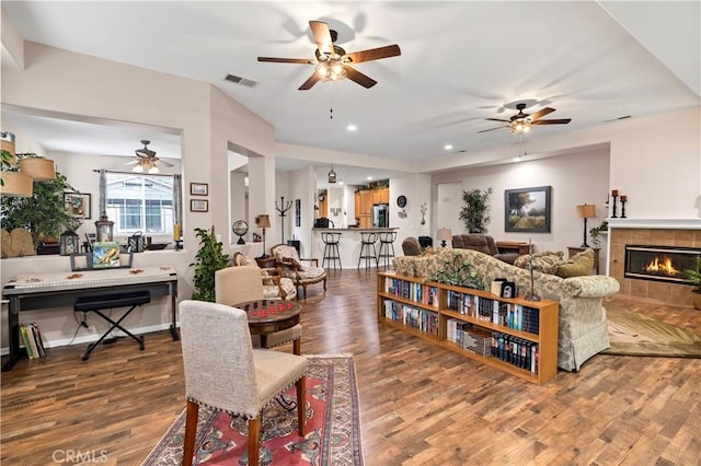 living room with visible vents, wood finished floors, and ceiling fan