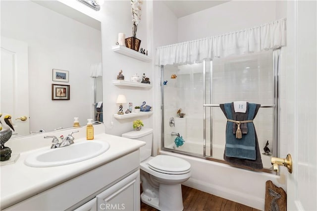 full bathroom featuring toilet, shower / bath combination with glass door, vanity, and wood finished floors