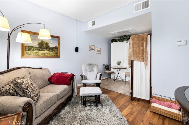 living area featuring hardwood / wood-style floors and visible vents