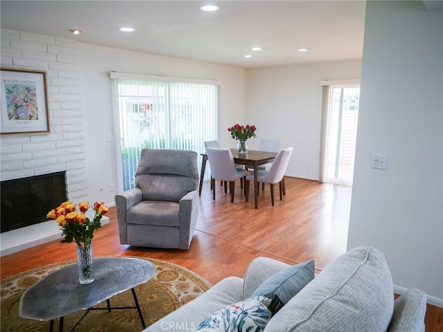 living room with a fireplace, light wood-type flooring, plenty of natural light, and recessed lighting