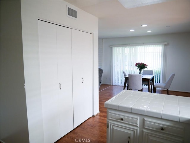 kitchen with visible vents, recessed lighting, dark wood-style flooring, tile counters, and baseboards
