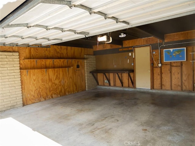 garage with wood walls and a garage door opener