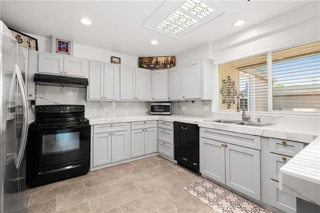 kitchen featuring a sink, black appliances, under cabinet range hood, decorative backsplash, and recessed lighting