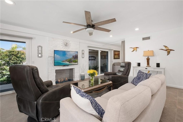 living area featuring visible vents, a ceiling fan, a stone fireplace, and recessed lighting