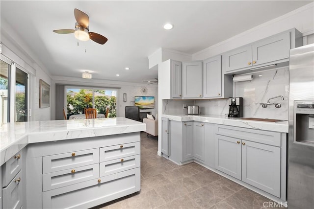kitchen featuring decorative backsplash, stainless steel fridge, ceiling fan, and gray cabinets
