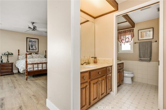9492 Brynmar Dr, Villa Park, CA 92861 - ensuite bathroom with tile walls, toilet, vanity, a ceiling fan, and wood finished floors