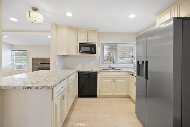 23821 Norma Dr, Menifee, CA 92587 - kitchen with black appliances, a sink, cream cabinets, a peninsula, and light wood finished floors