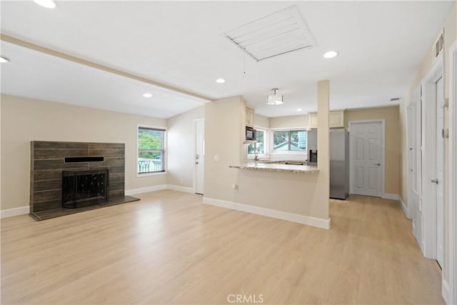 23821 Norma Dr, Menifee, CA 92587 - unfurnished living room with light wood finished floors, healthy amount of natural light, recessed lighting, baseboards, and a fireplace