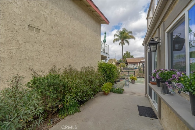 view of side of home with stucco siding and a patio area