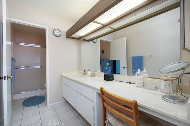 bathroom featuring toilet, vanity, tile patterned floors, a stall shower, and baseboards