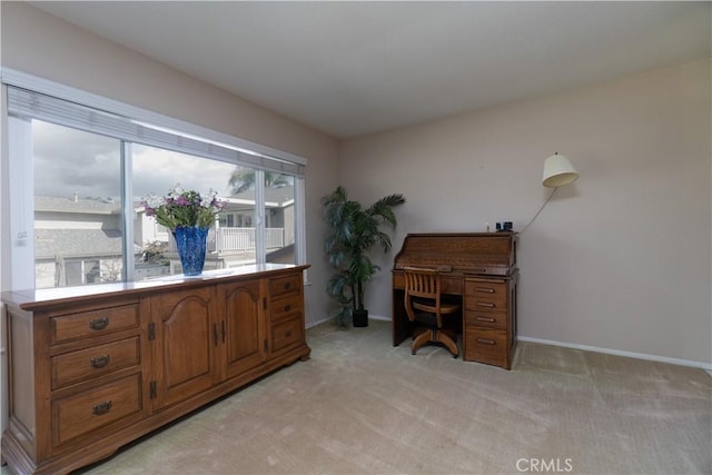 office space featuring light carpet and baseboards