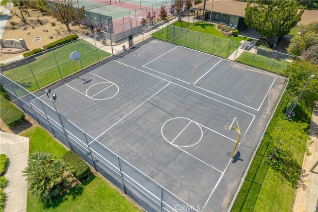 view of basketball court with a yard, fence, and community basketball court