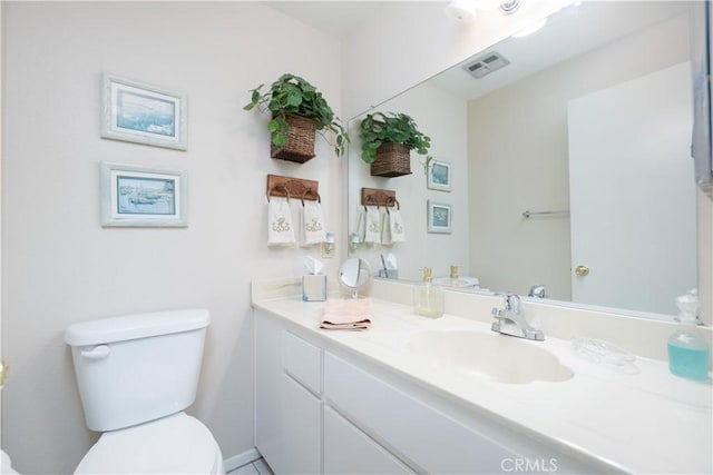 half bathroom featuring vanity, toilet, and visible vents
